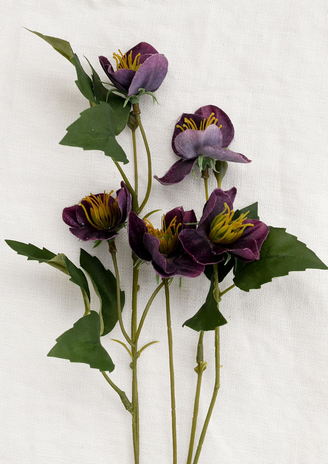 Artificial purple flowers with green leaves on a white background