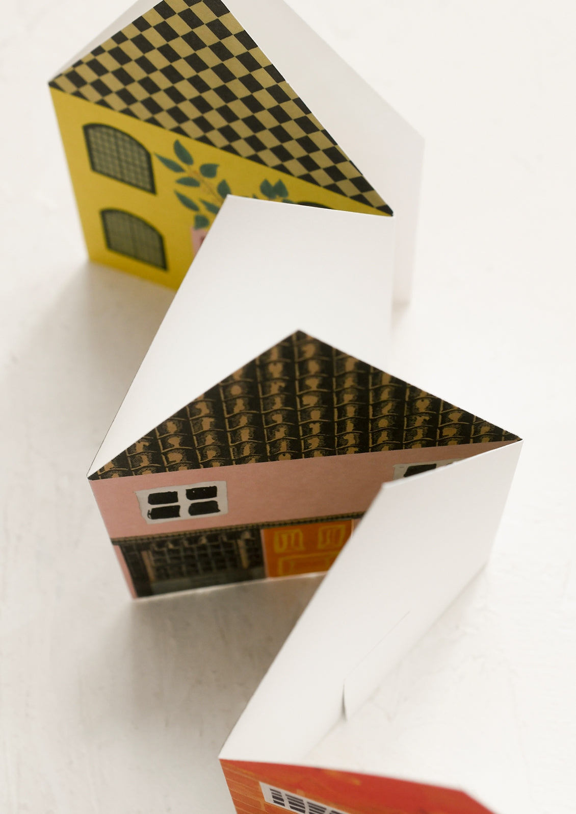 Small houses with different colored roofs on a white background