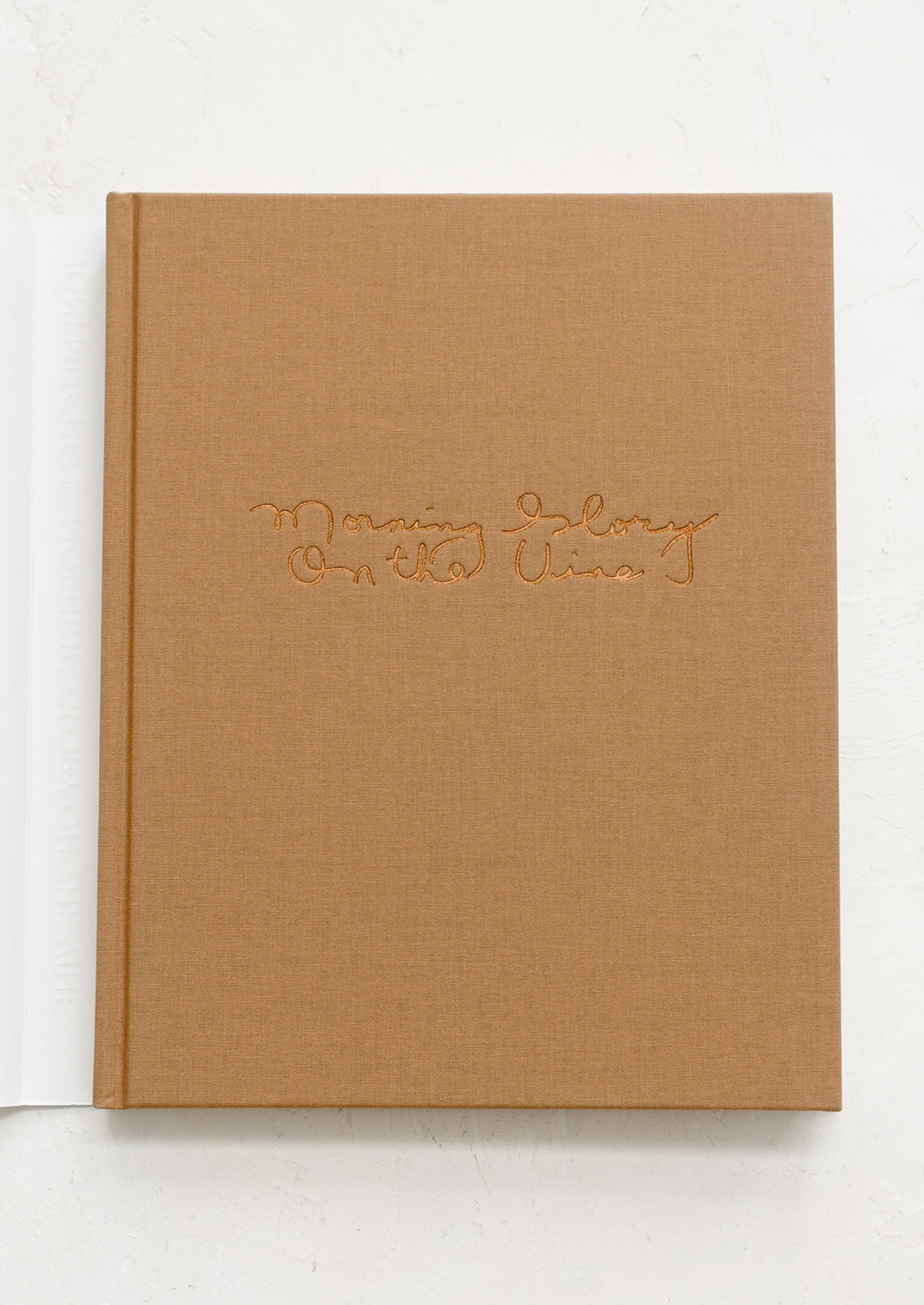 Brown cloth-bound book with embossed text on a white background