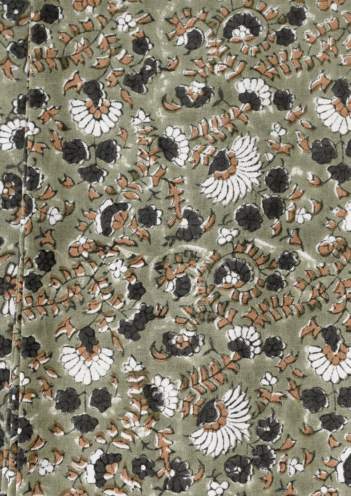 Close-up of a fabric with intricate floral pattern on a green background