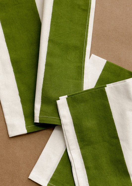 Green and white striped fabric strips on a brown background