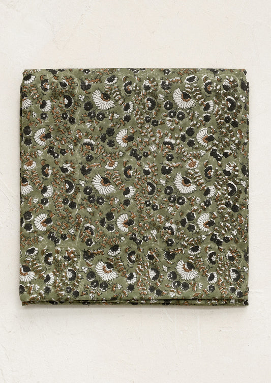 Square fabric swatch with a detailed pattern on a beige background
