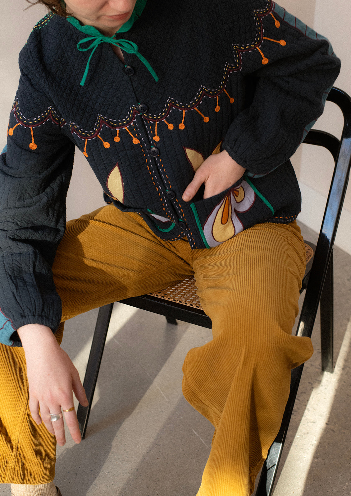 A woman wearing a pair of ochre colored wide leg corduroy pants.