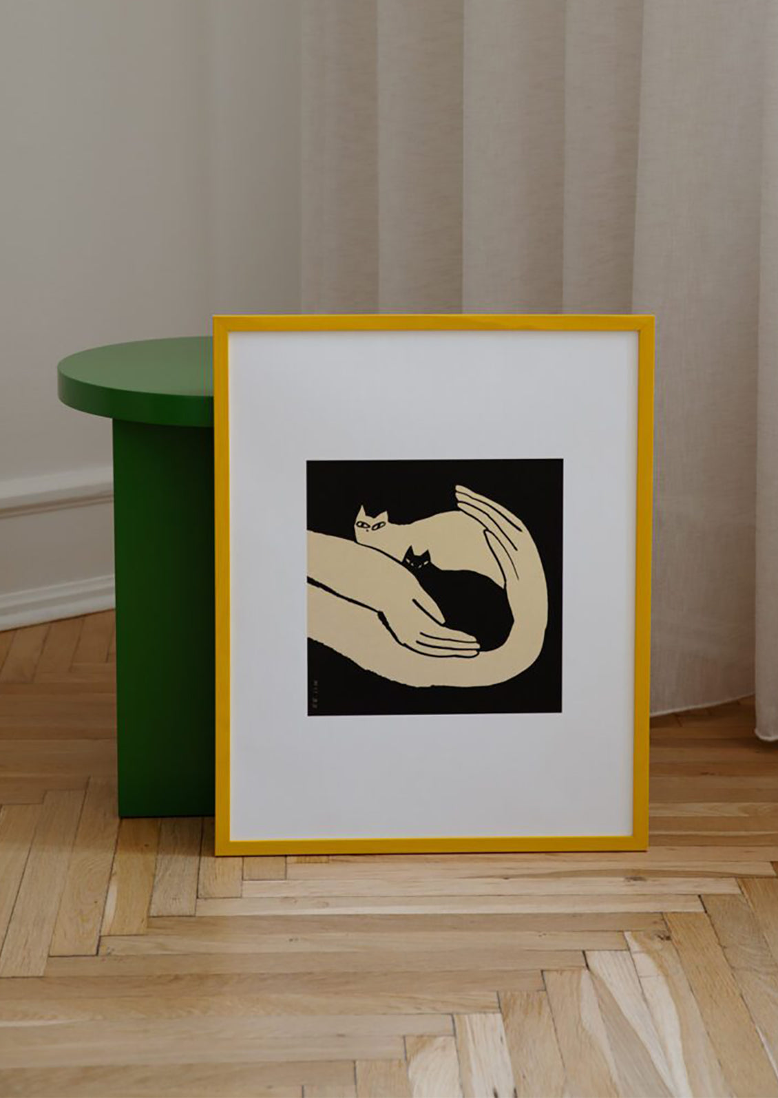 An art print in black and white of two kittens resting in human hands.