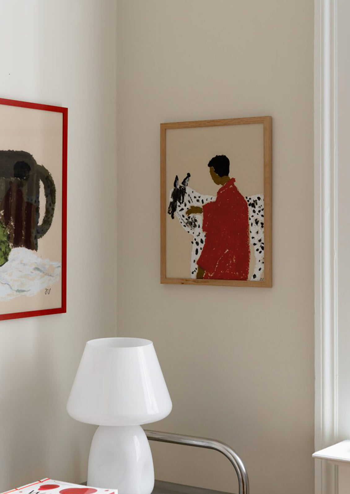 An art print of a painting of a woman with dark skin wearing a red jacket, petting a black and white spotted horse.
