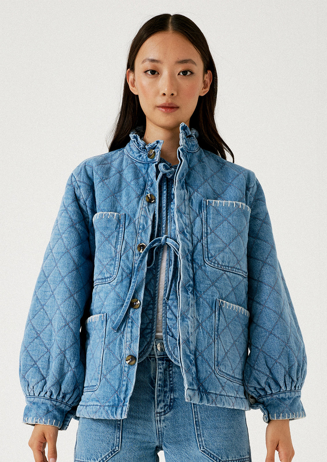A woman wearing a quilted denim chore coat.