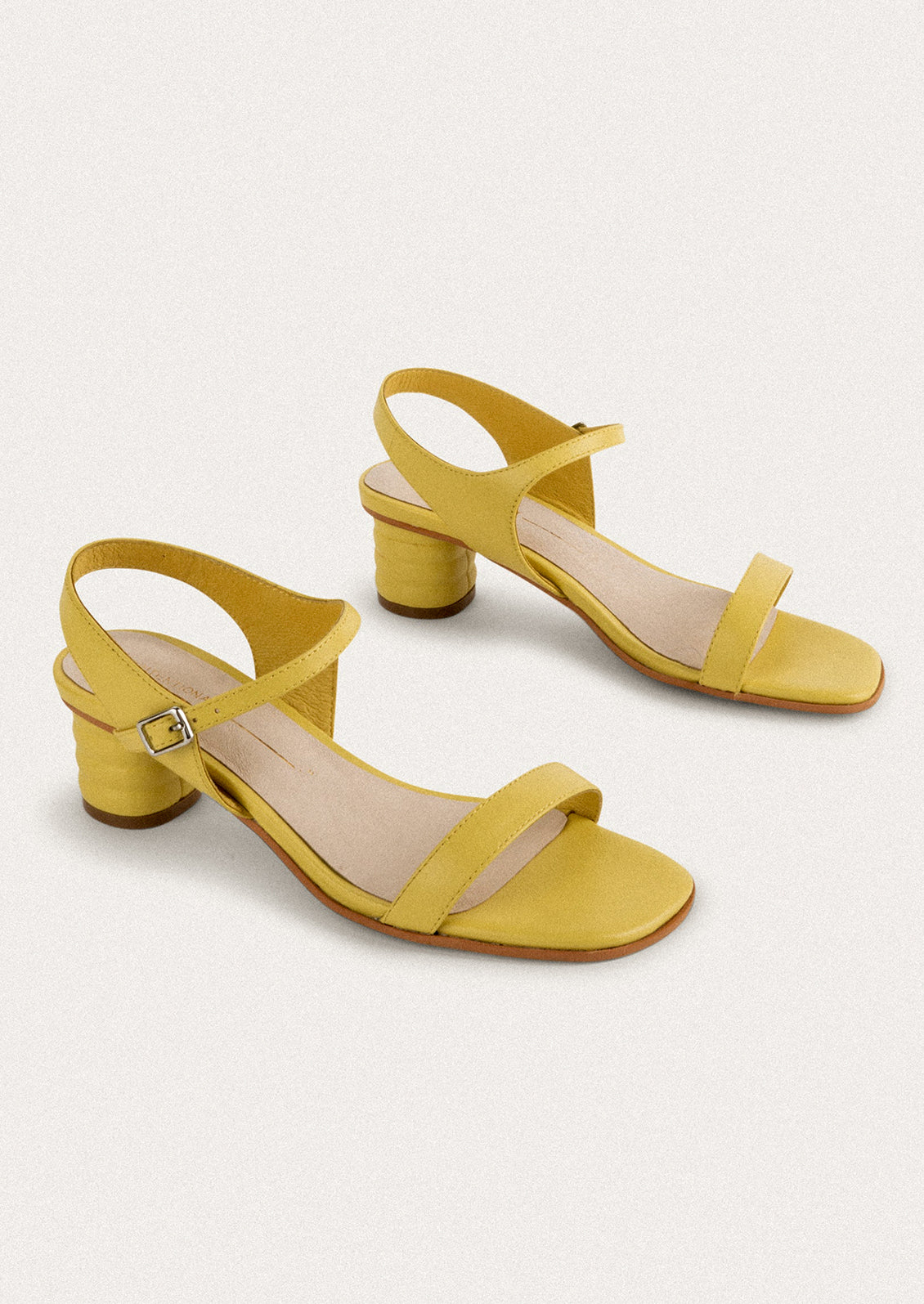A pair of heeled leather sandals in lemon yellow.