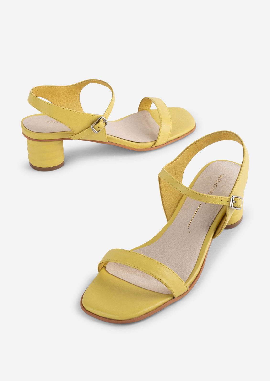 A pair of heeled leather sandals in lemon yellow.