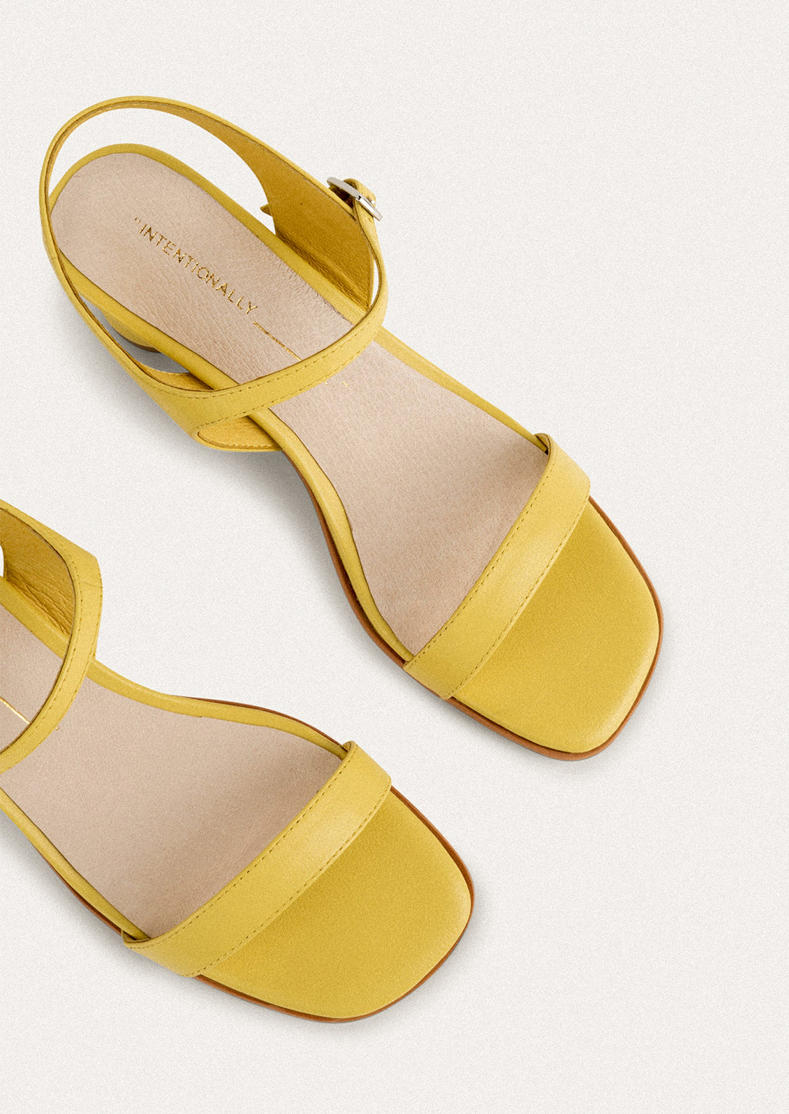 A pair of heeled leather sandals in lemon yellow.