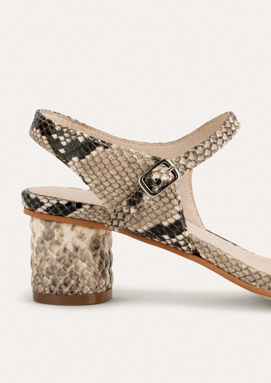 A pair of heeled leather sandals in snakeskin.