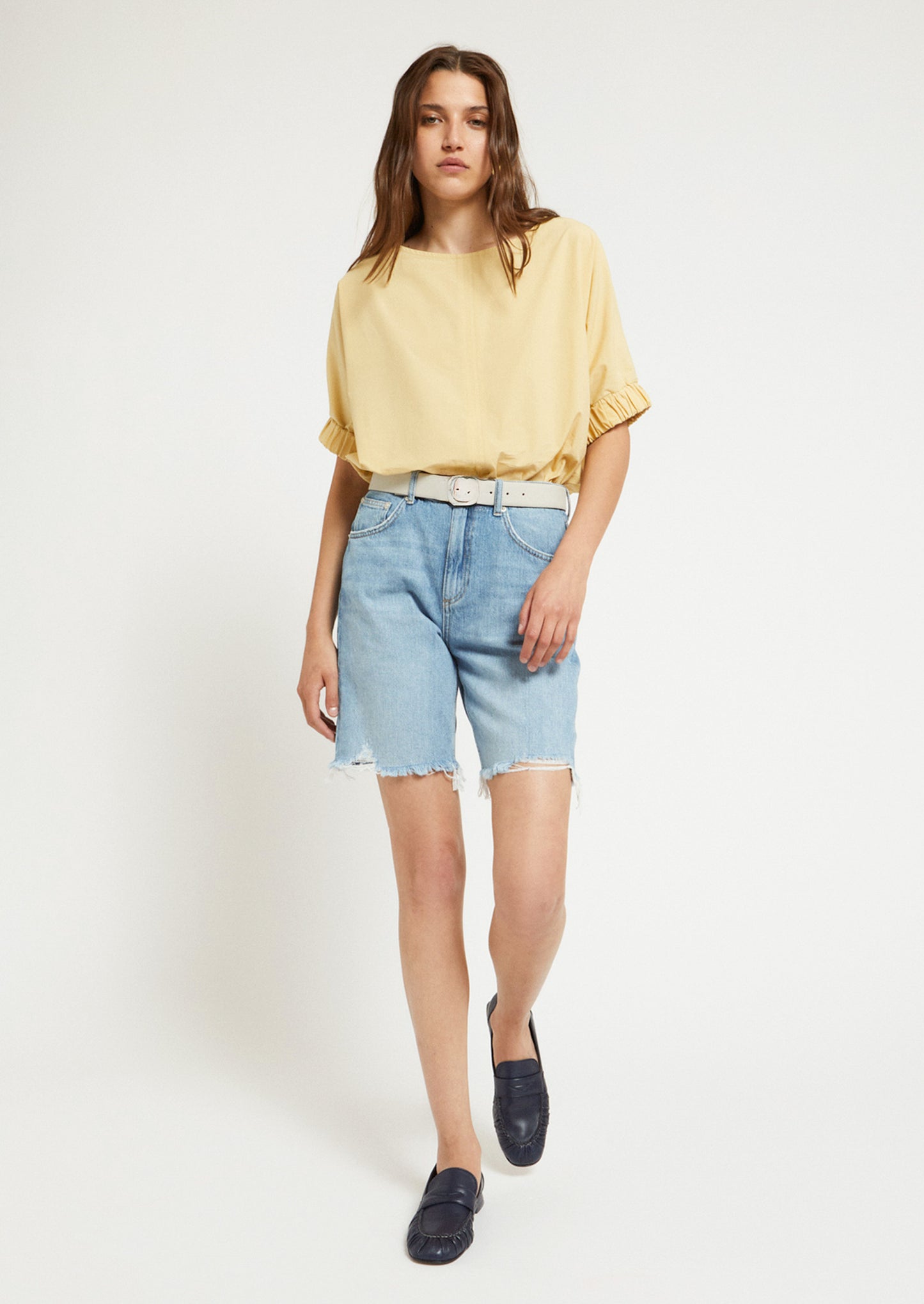 A woman wearing a short sleeve blouse in yellow color.