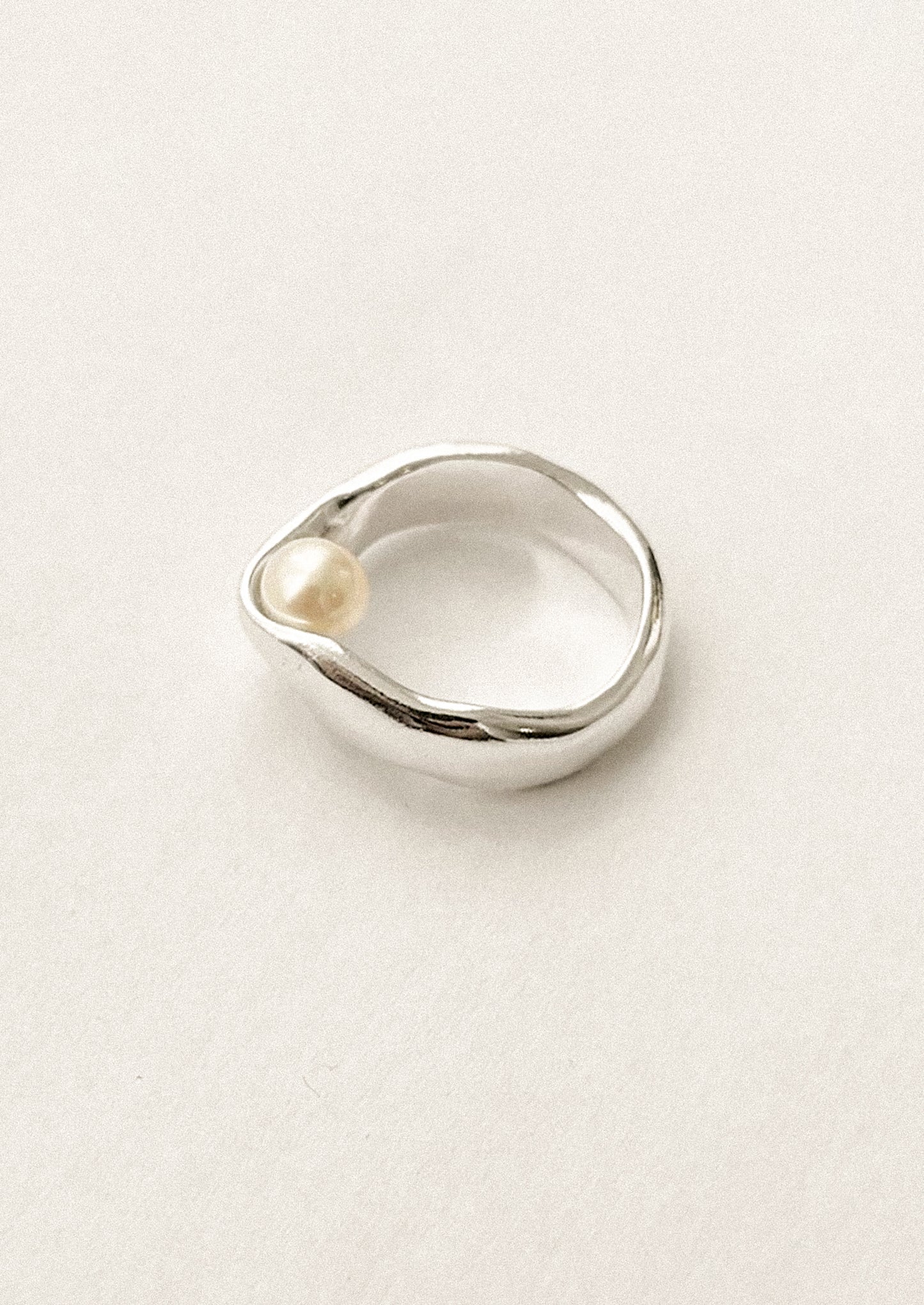 A sterling silver ring with inner pearl detail.