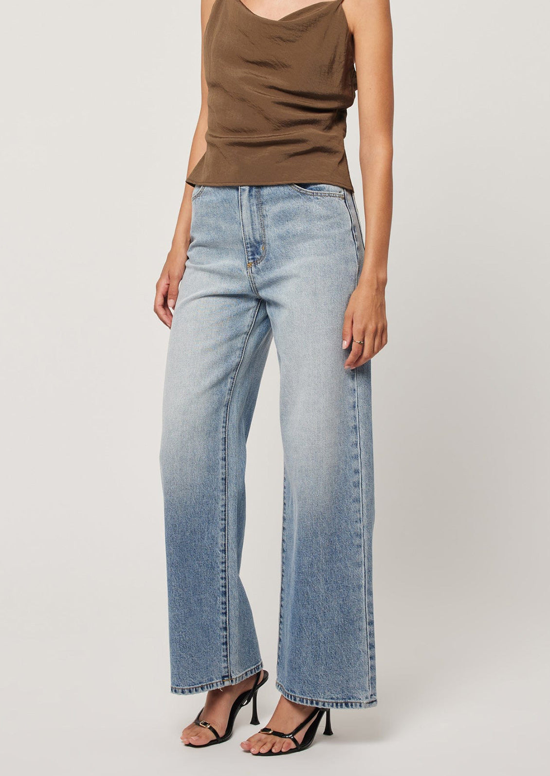 A person wearing a pair of wide leg blue jeans.