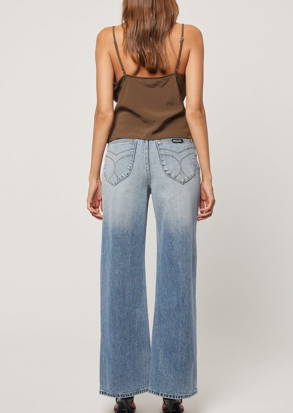 A person wearing a pair of wide leg blue jeans.