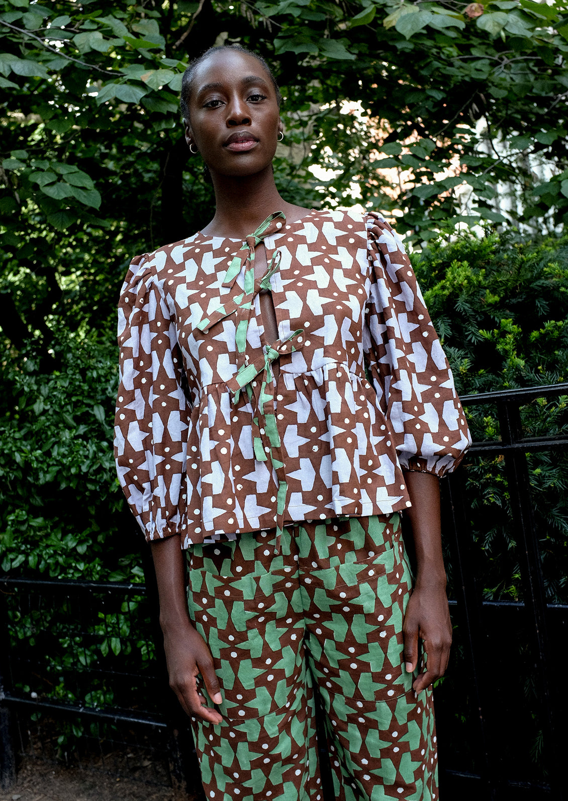 A person wearing a puff sleeve shirt with contrast tie front.