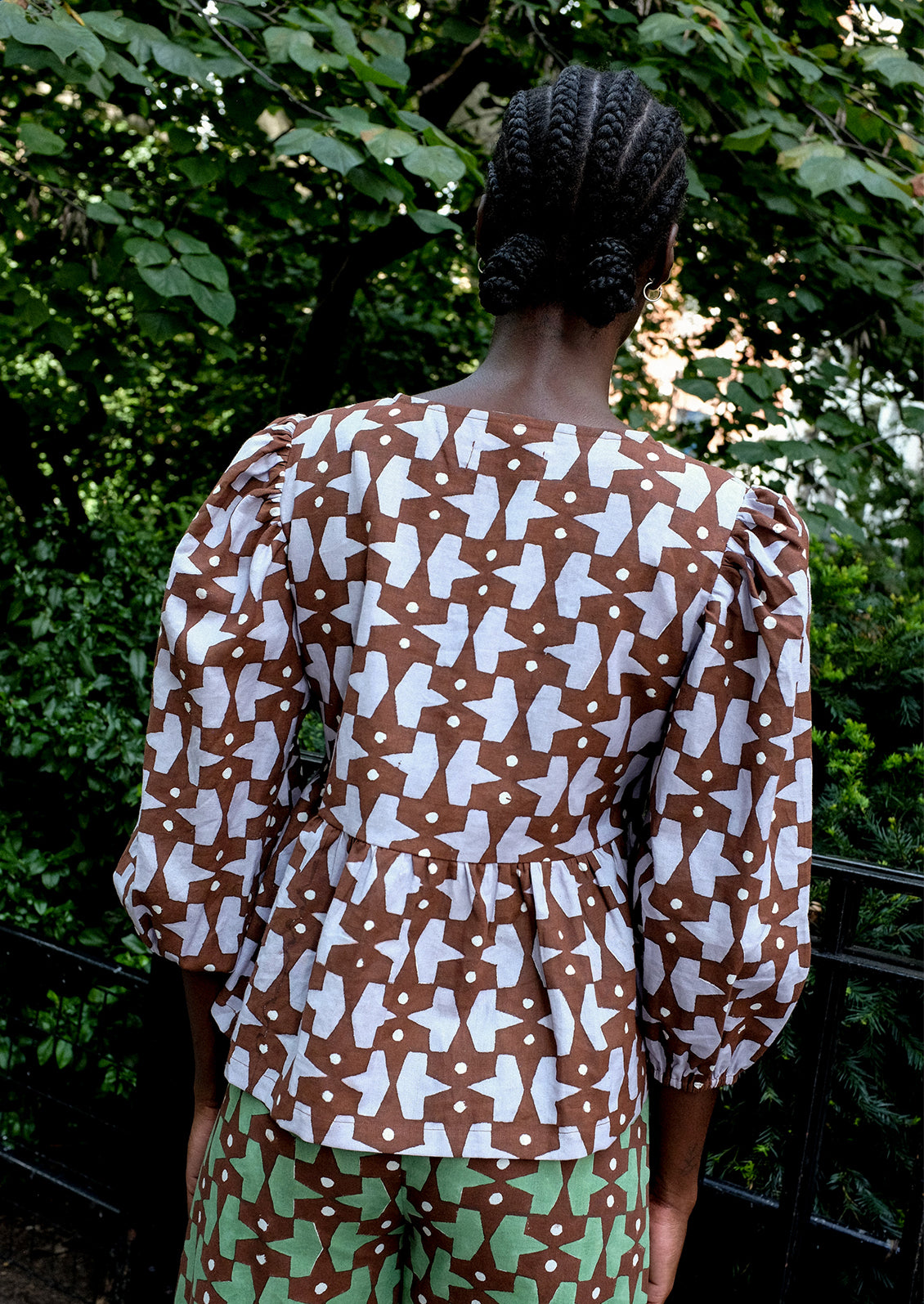 A person wearing a puff sleeve shirt with contrast tie front.