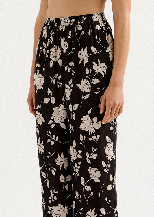 A person wearing a pair of monochrome floral pants in black and white.