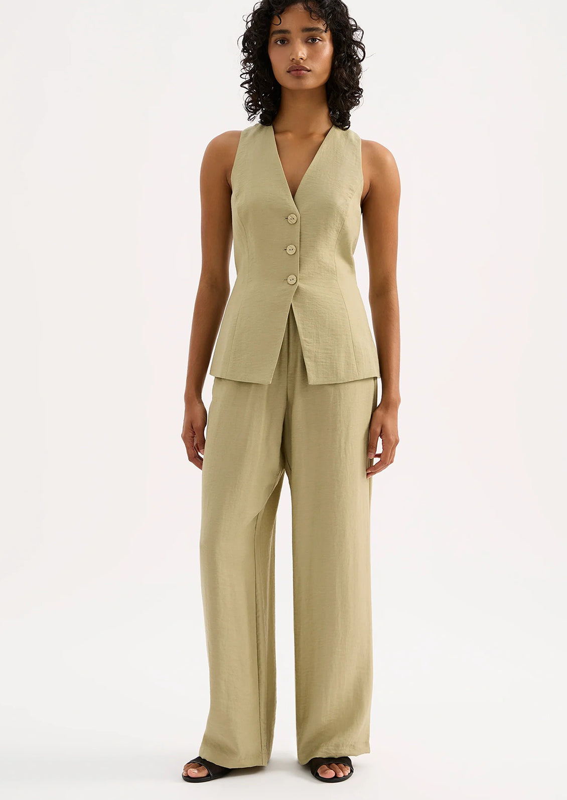 A woman wearing a light green suiting vest.