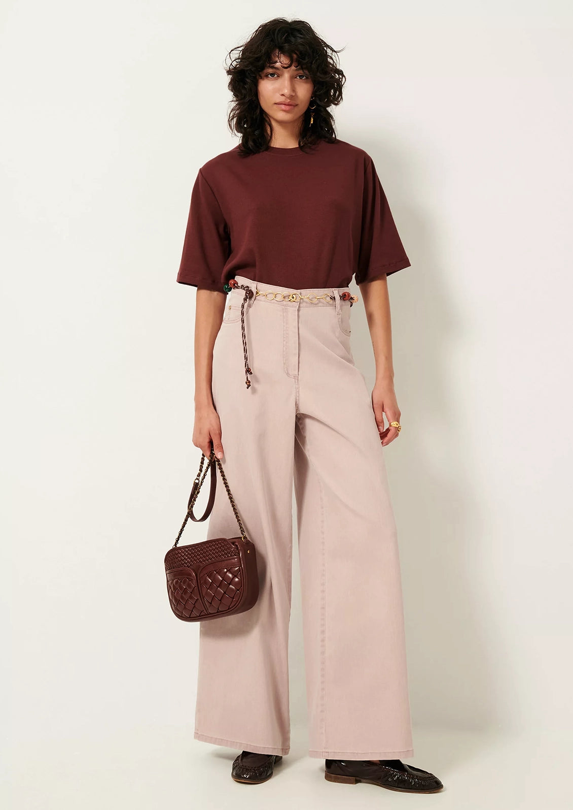 A woman wearing a short sleeve t-shirt with cuffs rolled up.