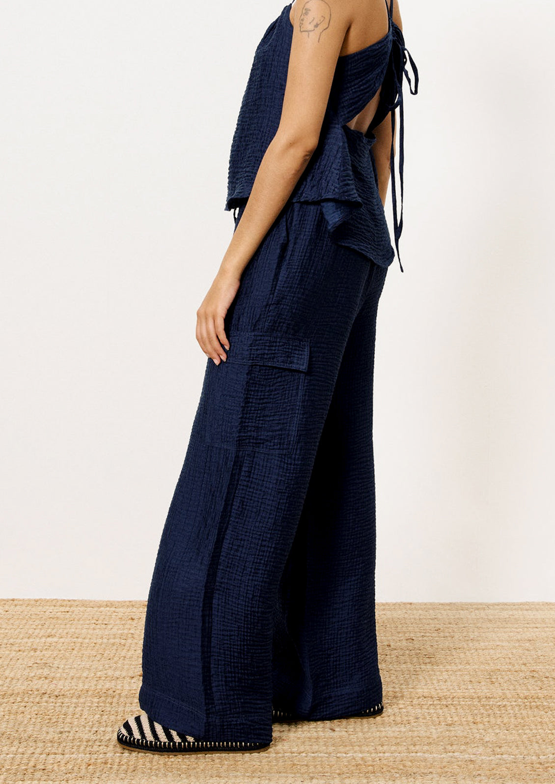 A person wearing a pair of navy blue crinkle texture cargo pants.