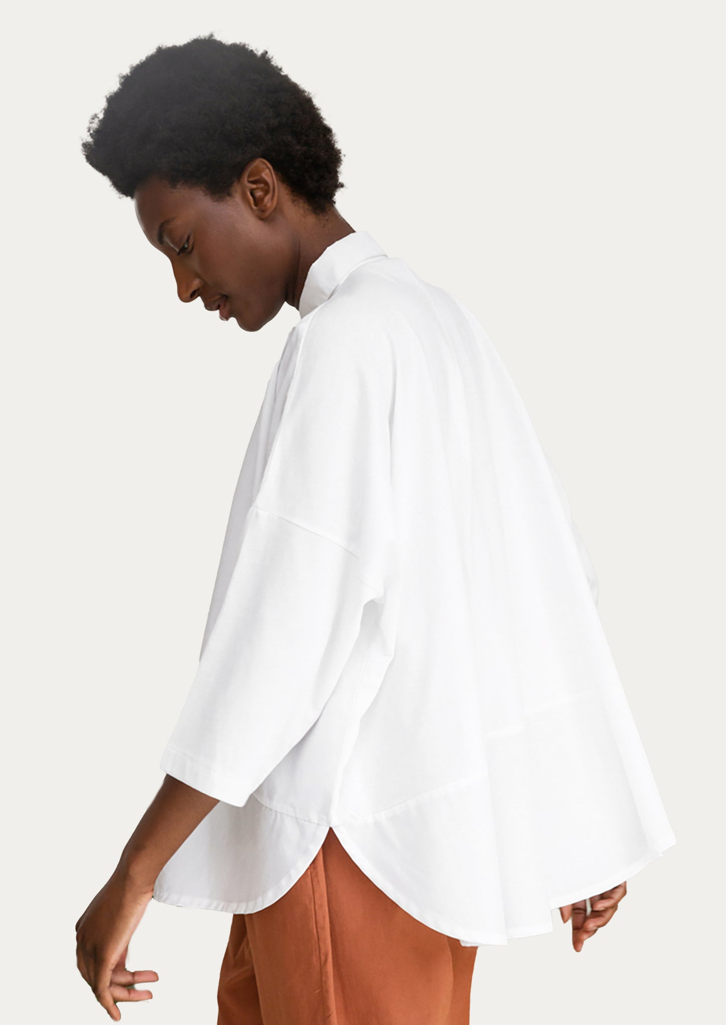 A woman wearing a blousy white cotton shirt.