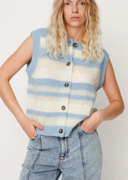 A woman wearing a striped blue and cream sweater vest.