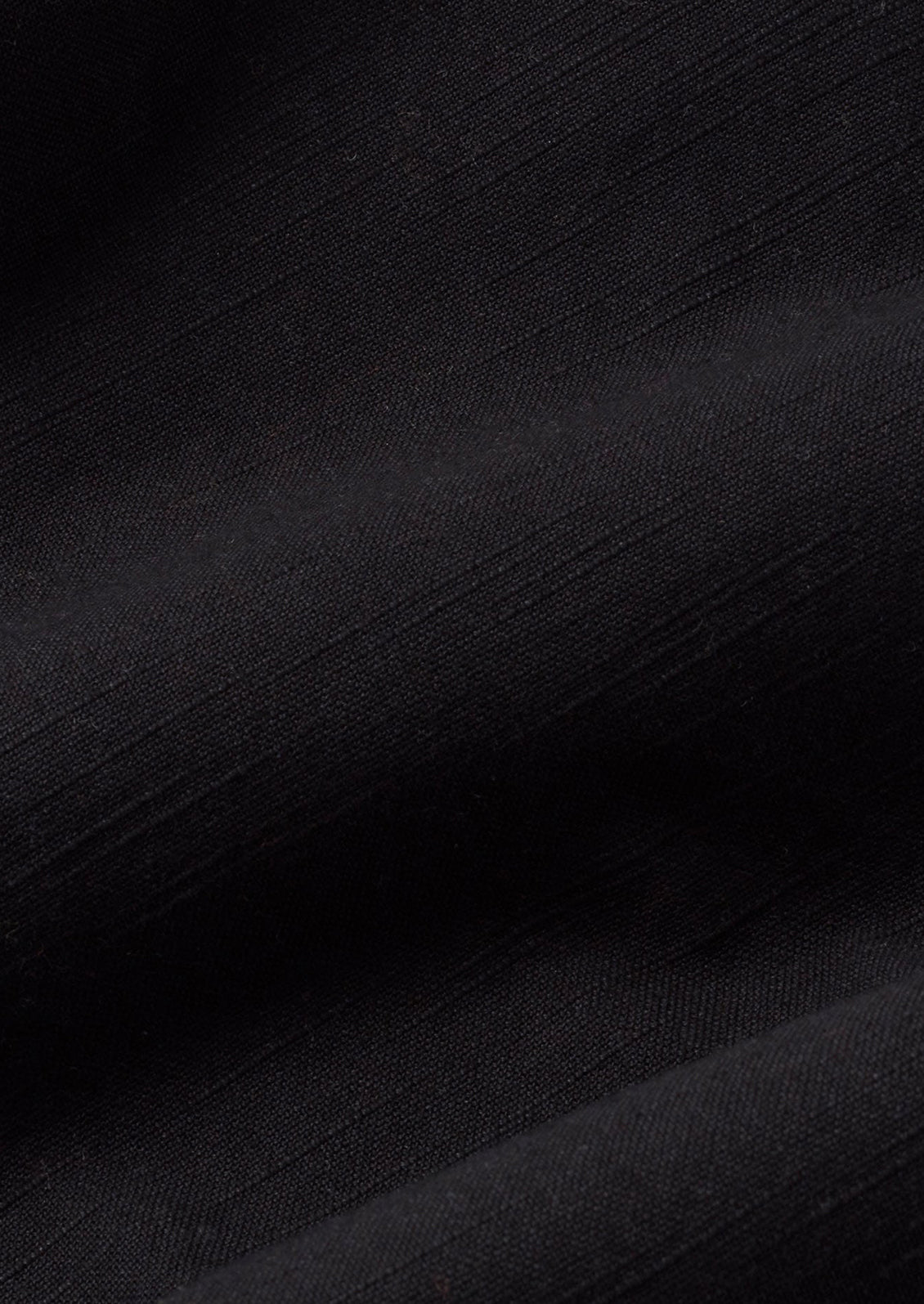 A person wearing a pair of ankle length cotton pants in black with slight wide leg.