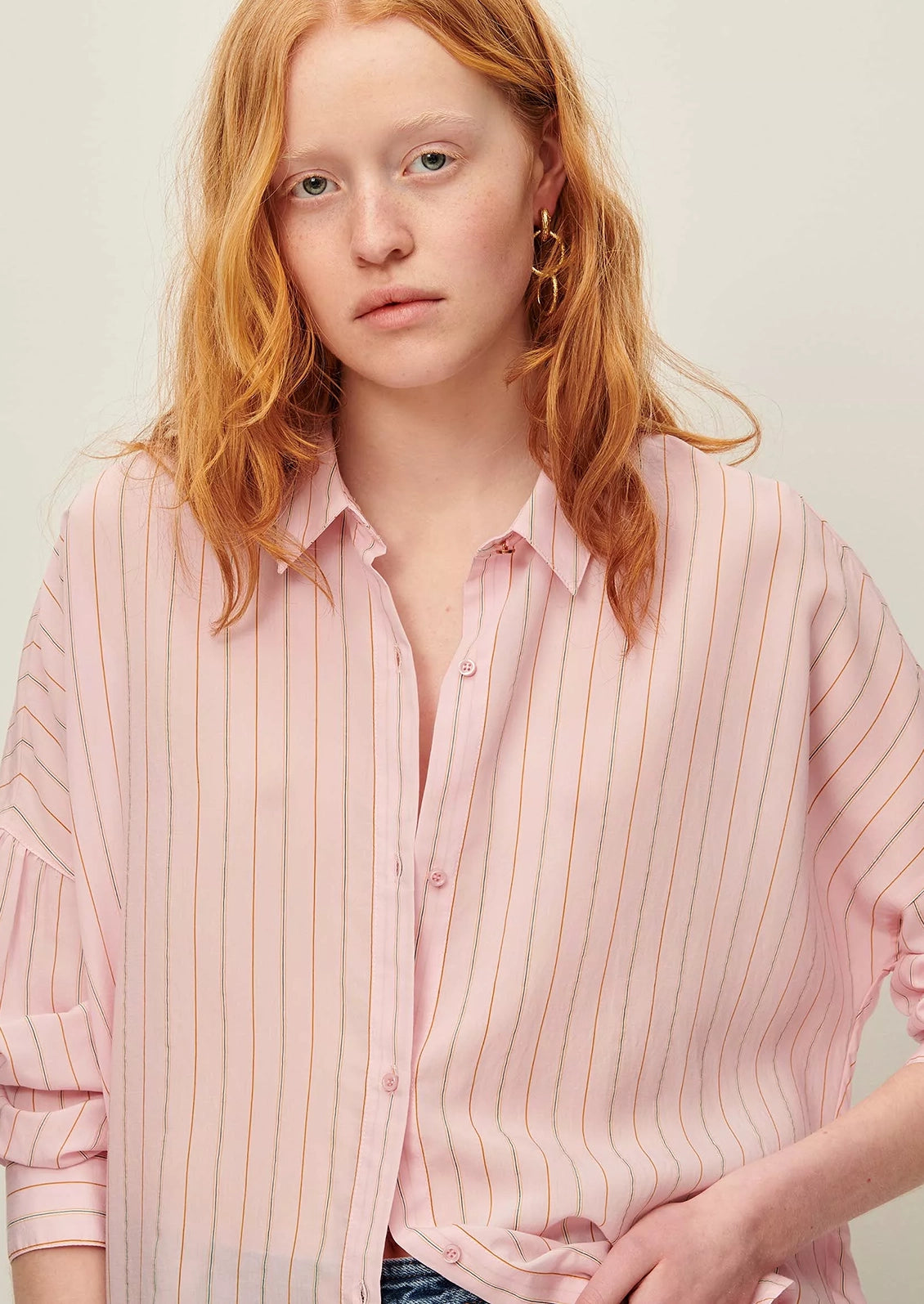 A button front shirt in pink with fine multicolor pinstripe pattern.
