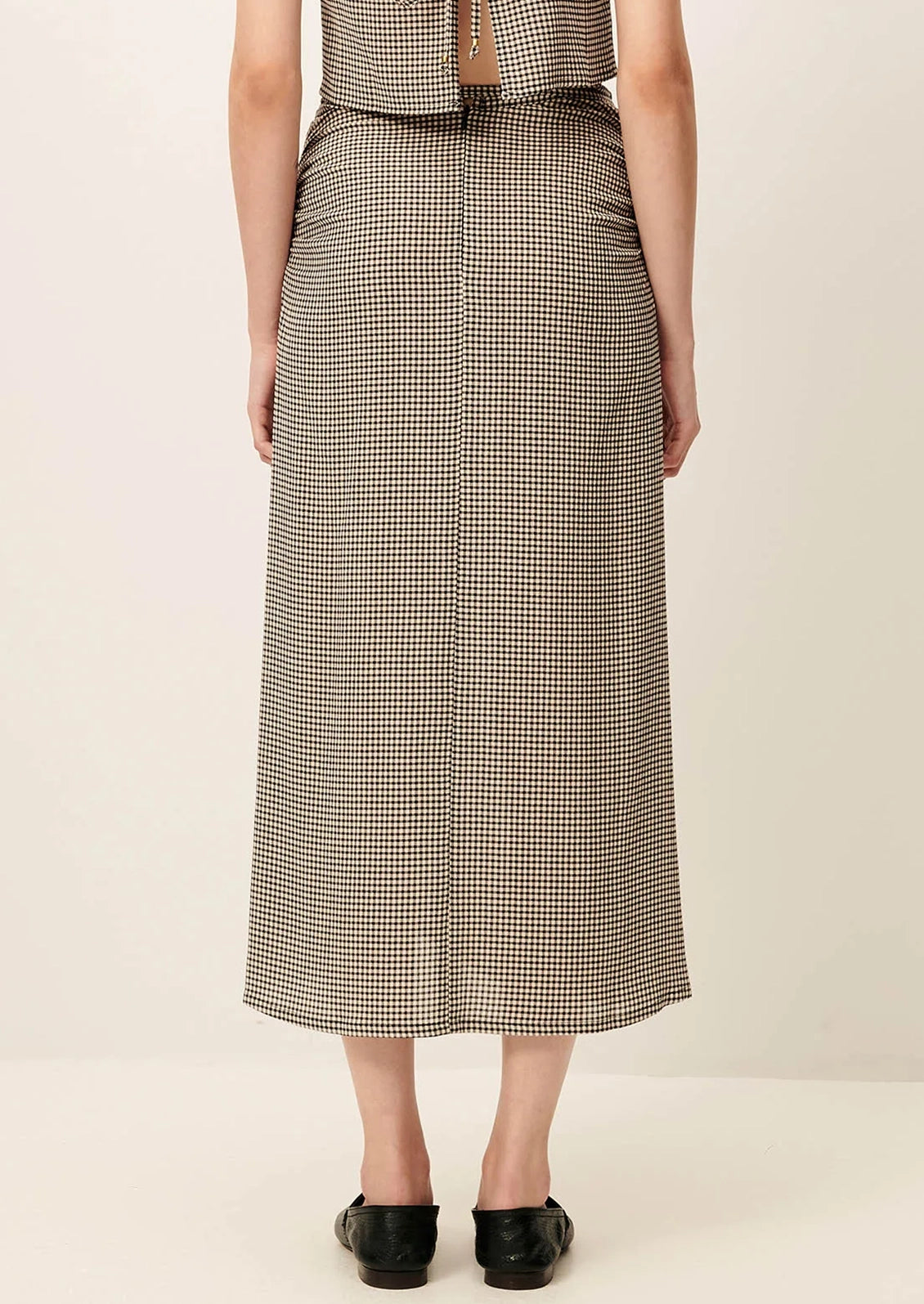 Person wearing a plaid dress on a plain background