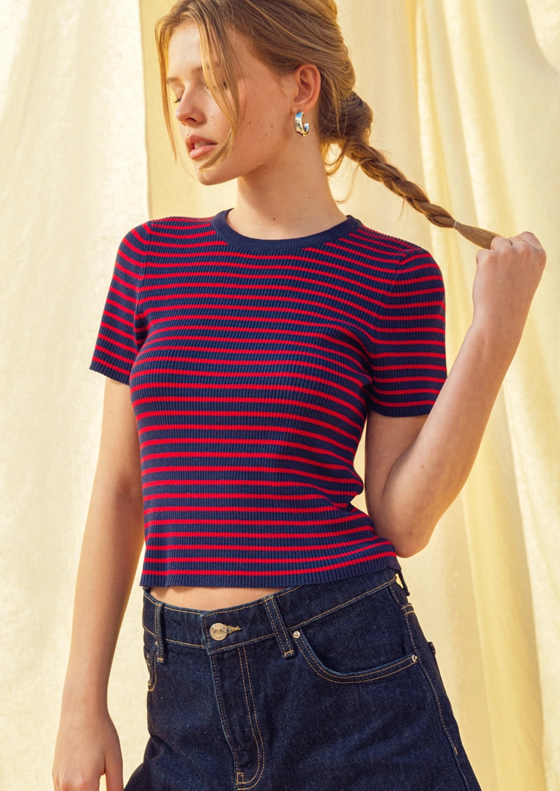 A woman wearing a short sleeve t-shirt in red and navy stripes.