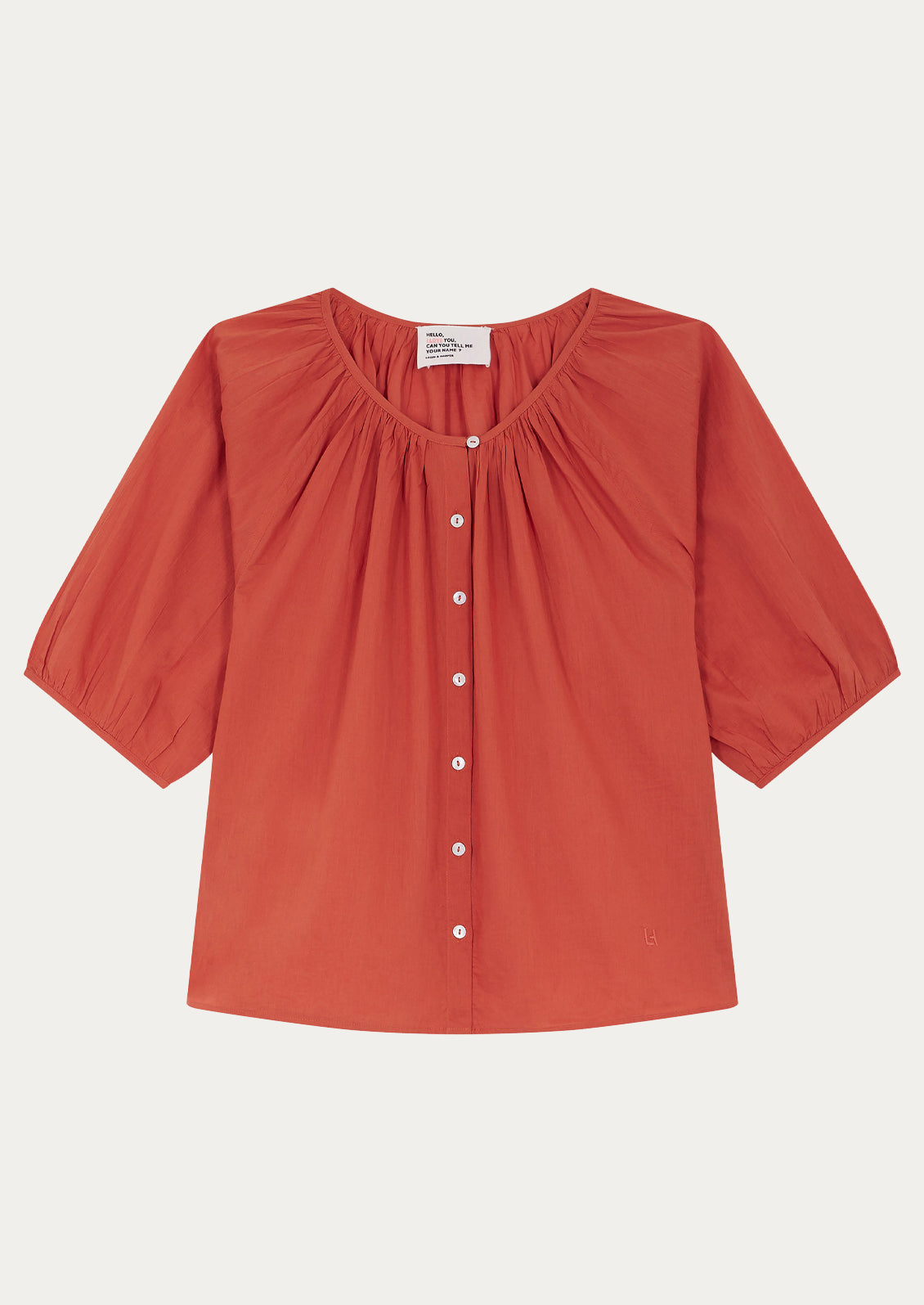 A short sleeve blouse in coral red color with shirring at neckline.