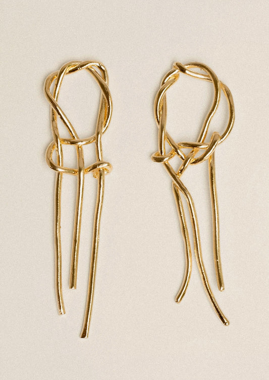 A pair of gold dangling intertwined earrings.