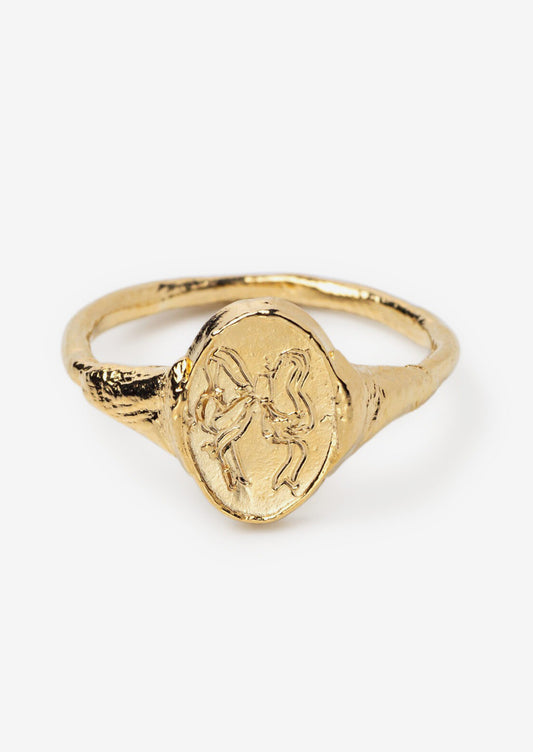 A gold signet ring with etching of a bow.