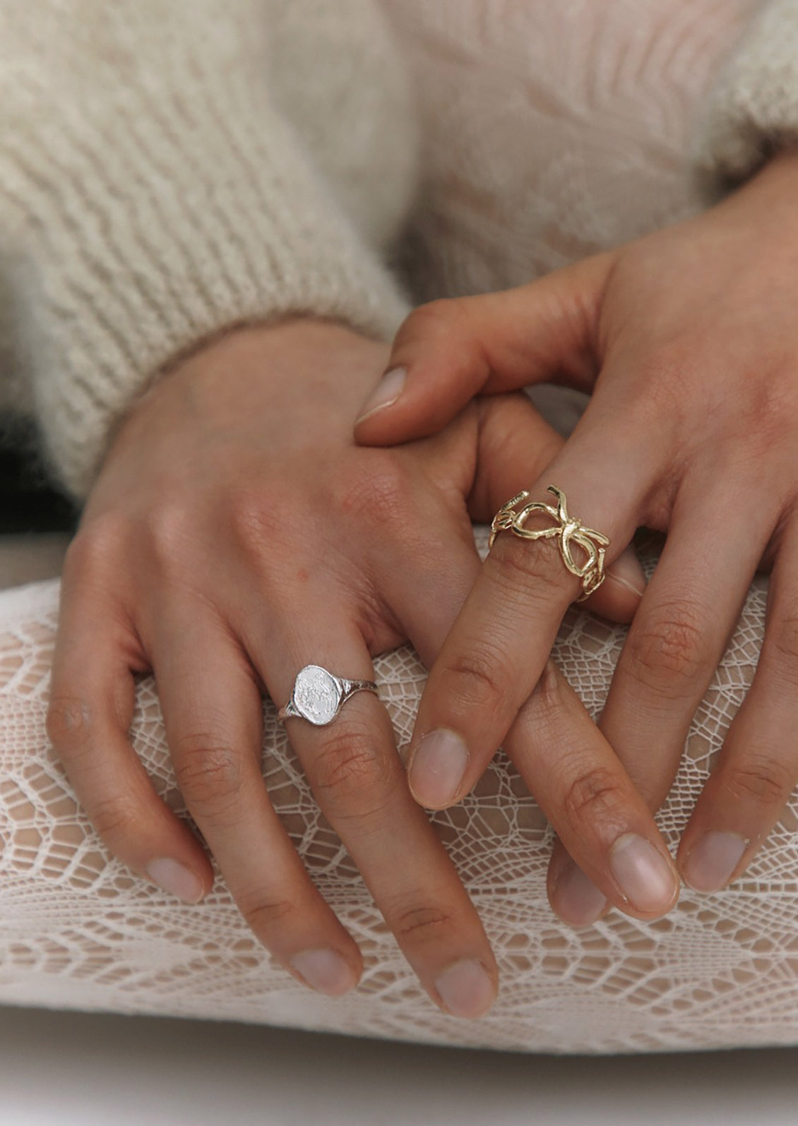 A woman wearing gold and silver rings.