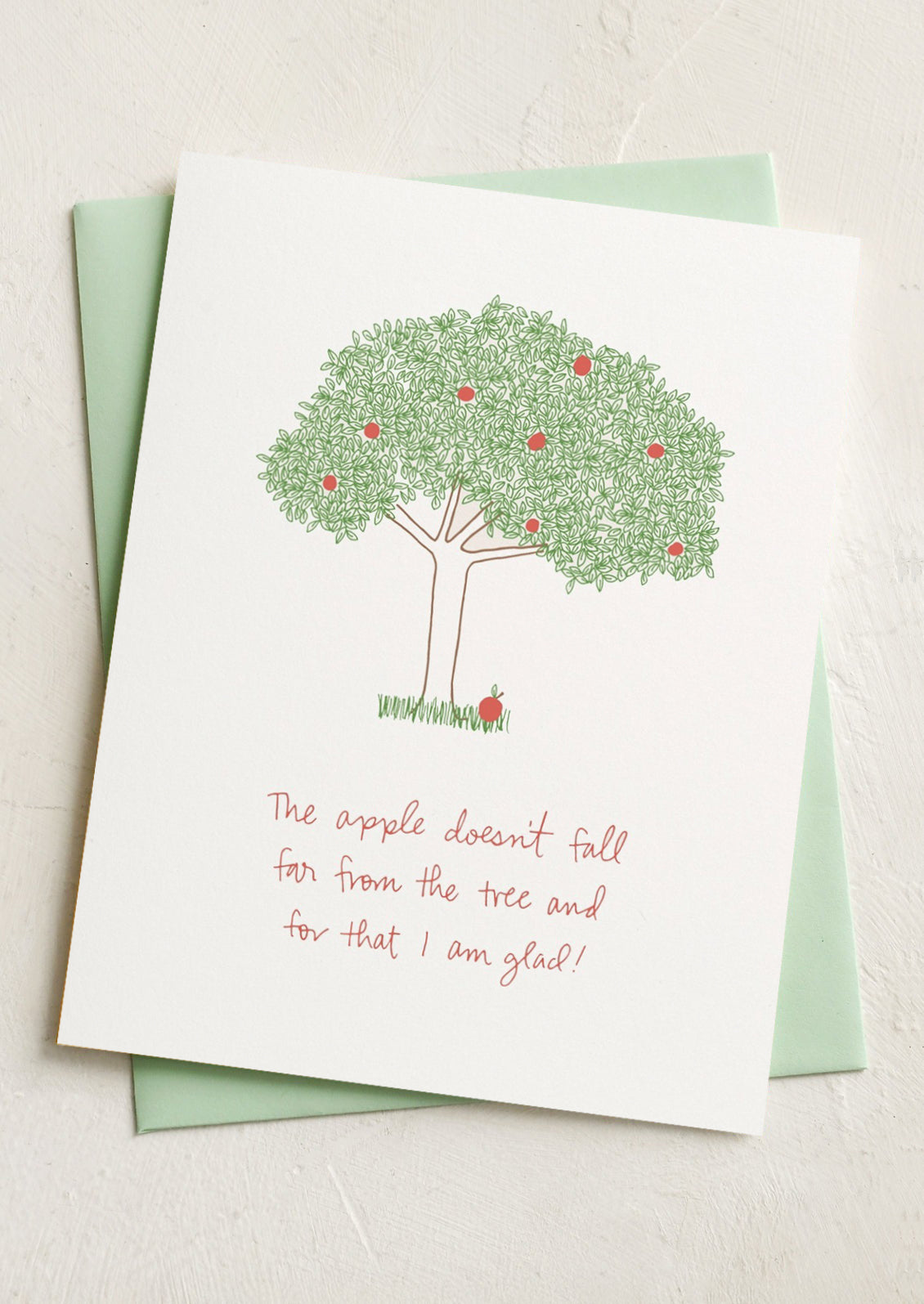 A card with image of an apple tree, text reads "The apple doesn't fall far from the tree and for that I am glad!".