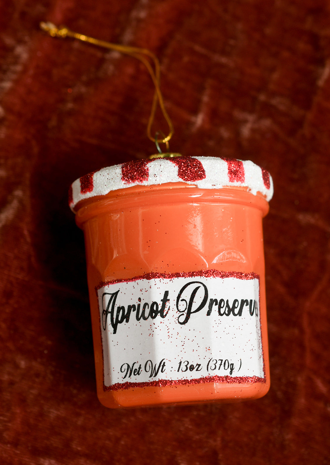 A glass ornament resembling Bonne Maman Apricot Preserves jam jar.