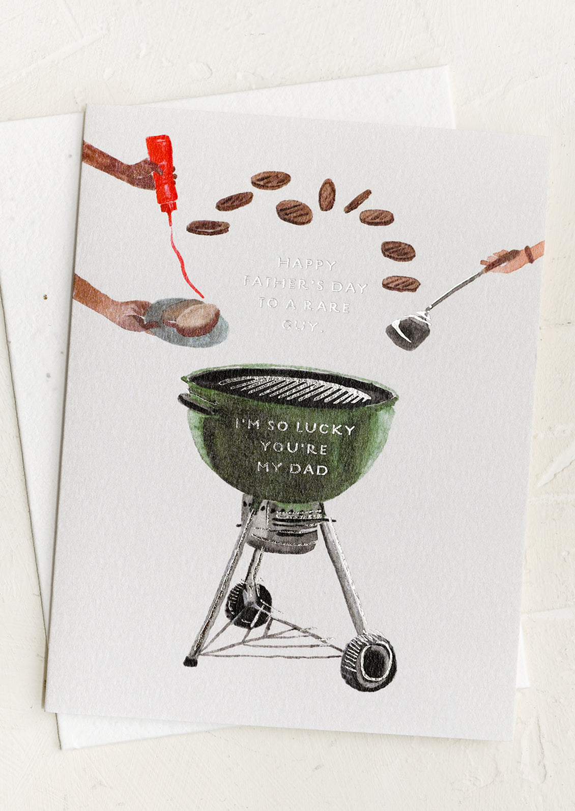 A card with image of burgers and grill, text reads "Happy Father's Day To A Rare Guy".