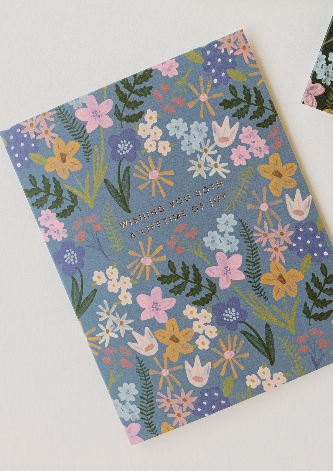 A blue floral print card reading "Wishing you both a lifetime of joy".