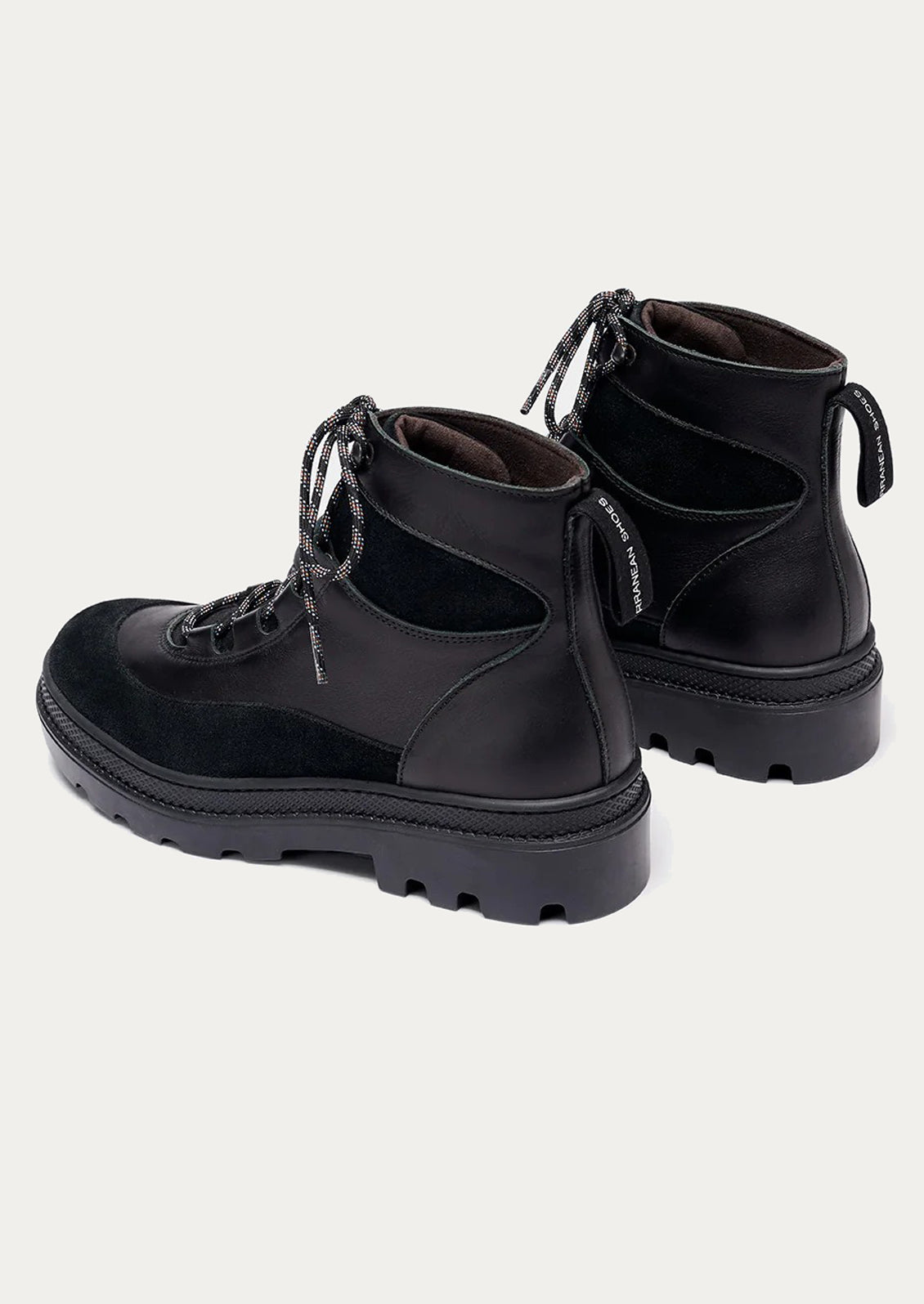 Pair of black boots on a light gray background