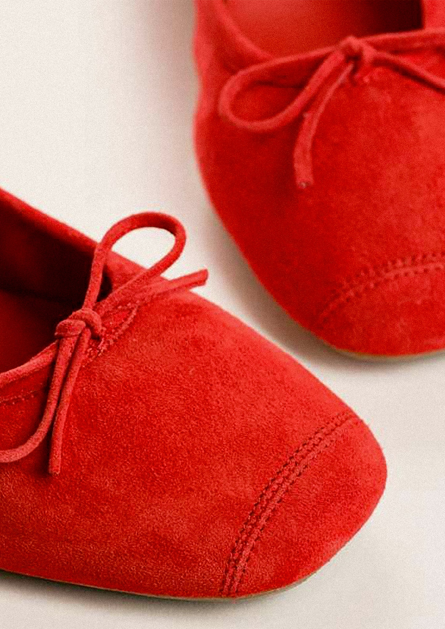 A pair of suede ballet flats in red.