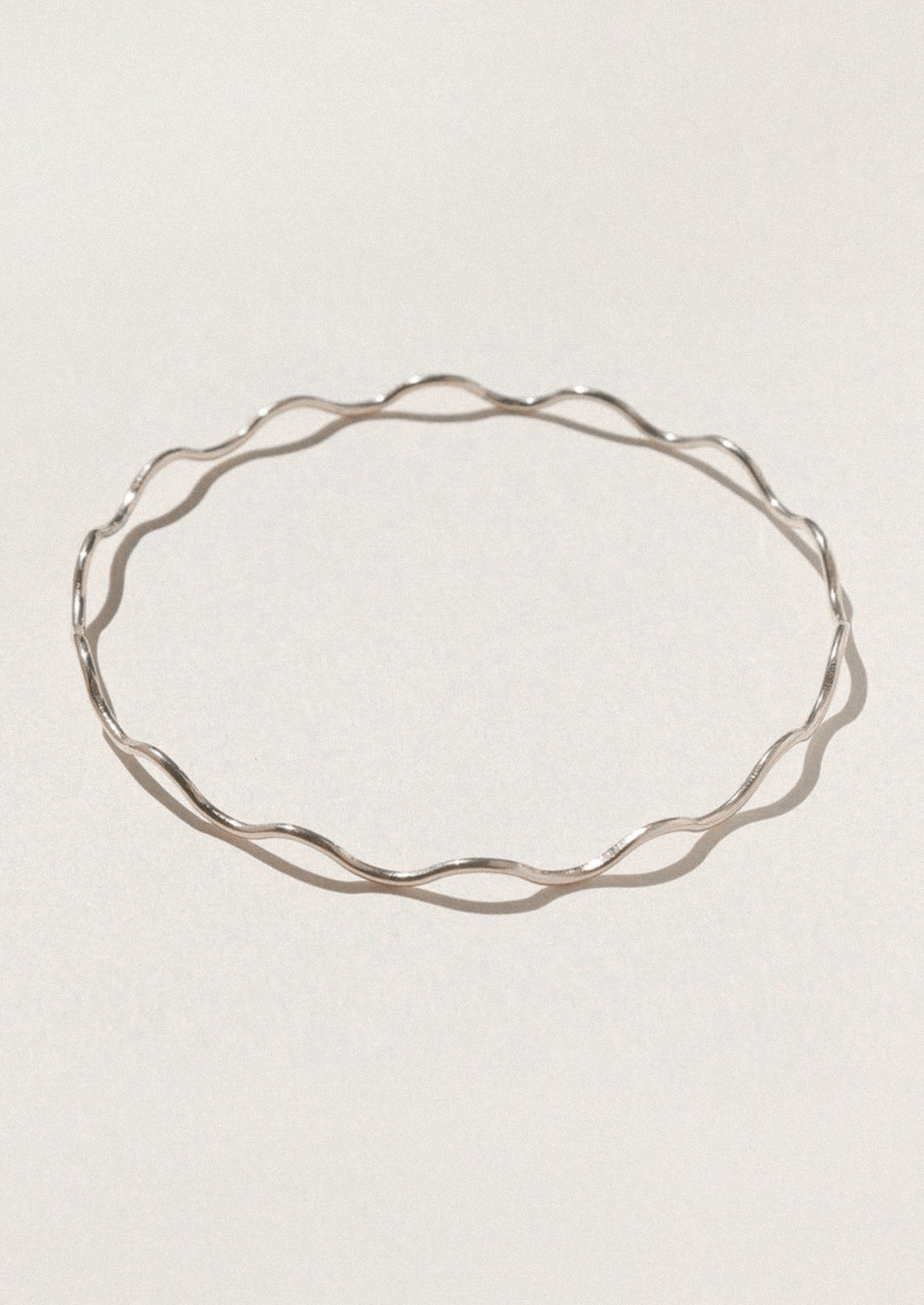Silver bracelet on a light gray background