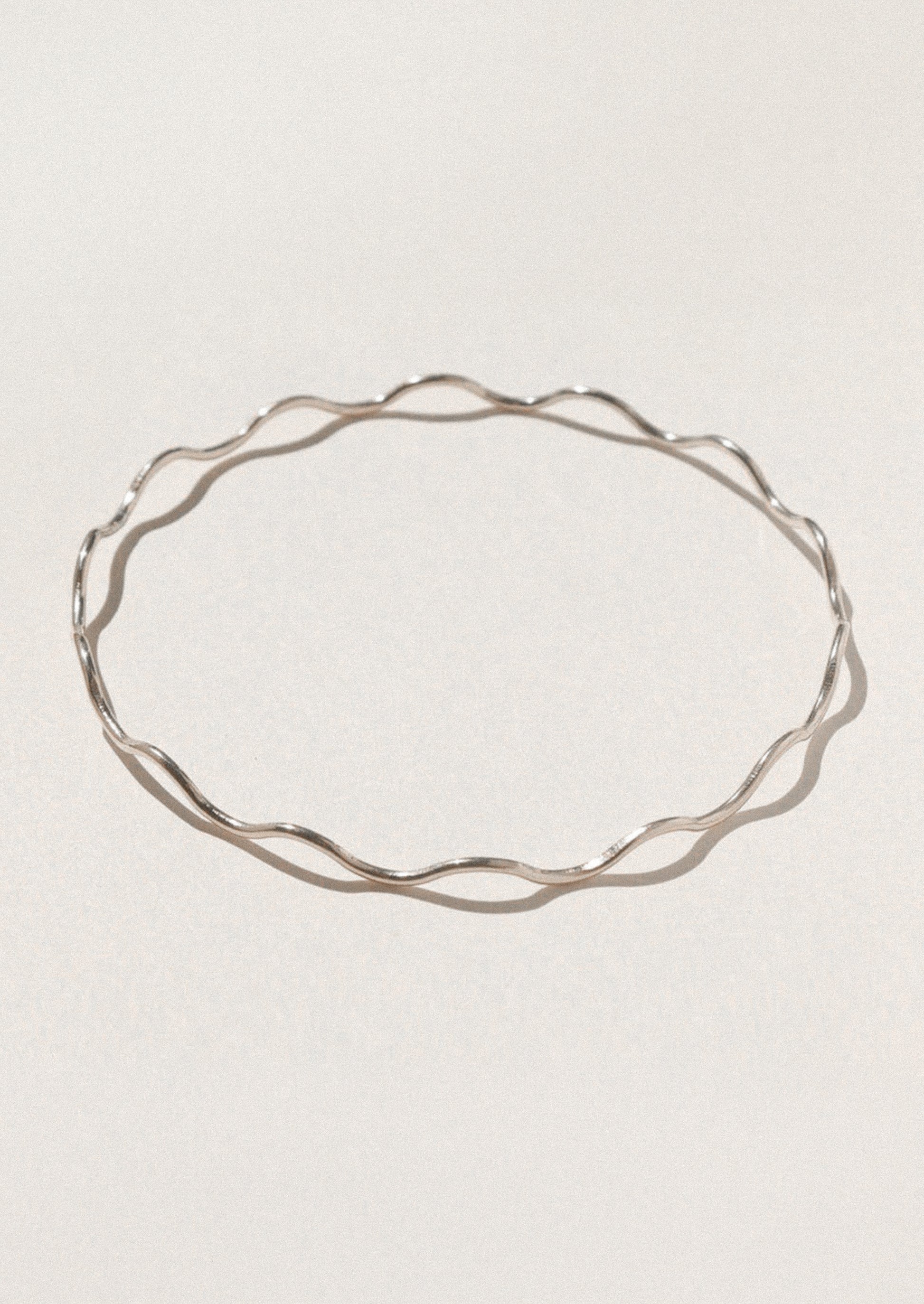 Silver bracelet on a light gray background