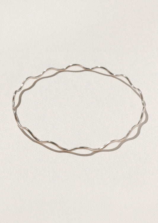 Silver bracelet on a light gray background