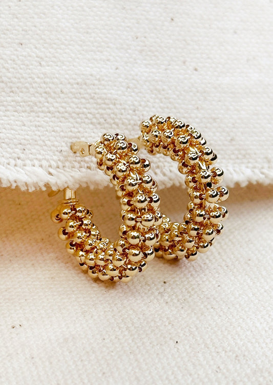 A pair of hoop earrings with all around cluster beading.