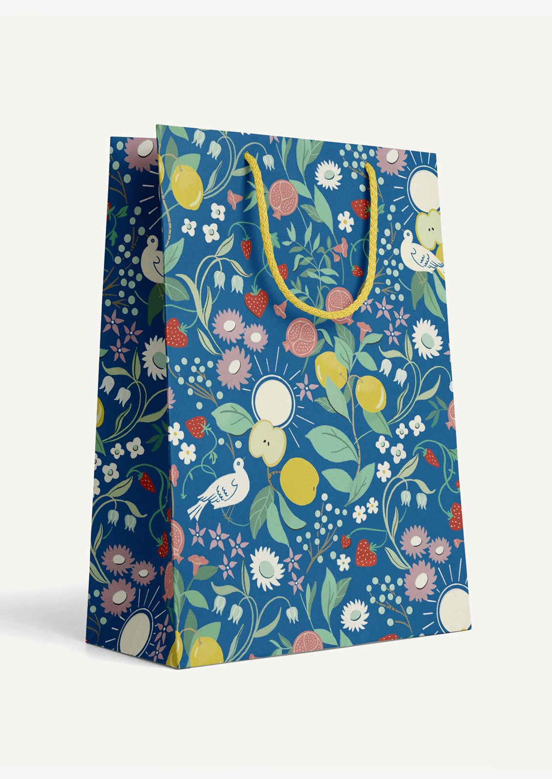 A printed gift bag with fruit and flower print on blue background.