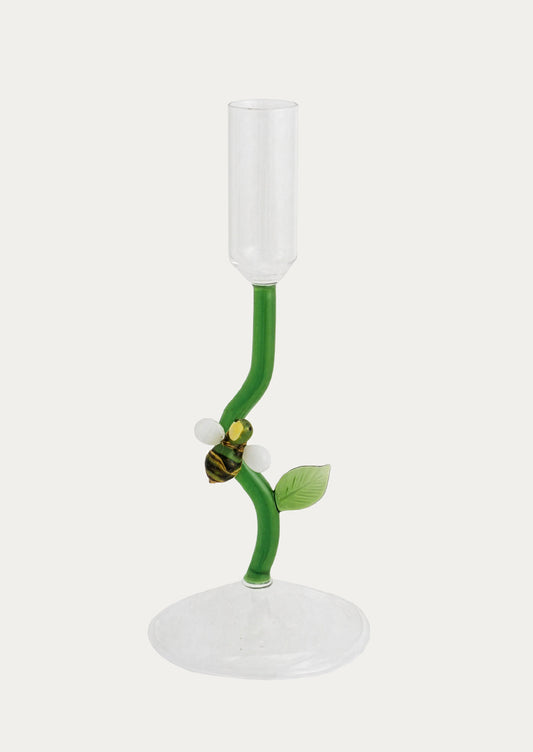 Glass candle holder with green stem and bee design on a white background
