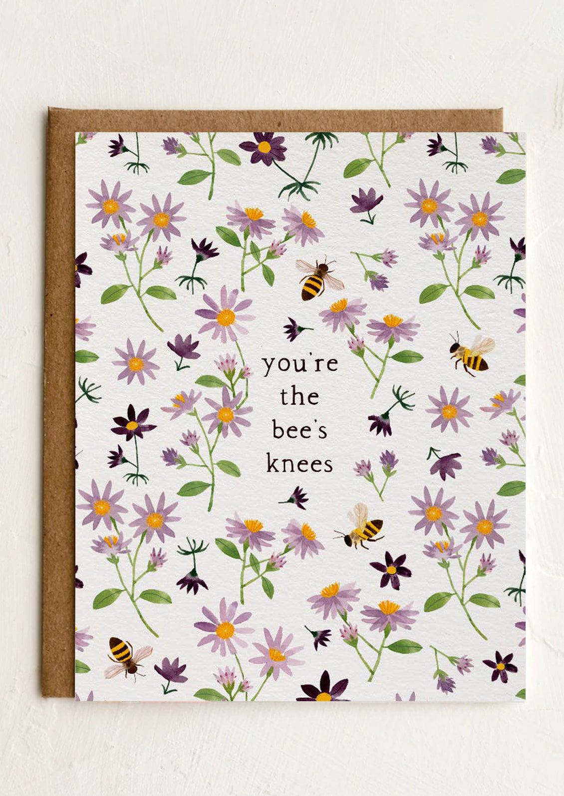 Greeting card with floral design and text 'you're the bee's knees' on a white background