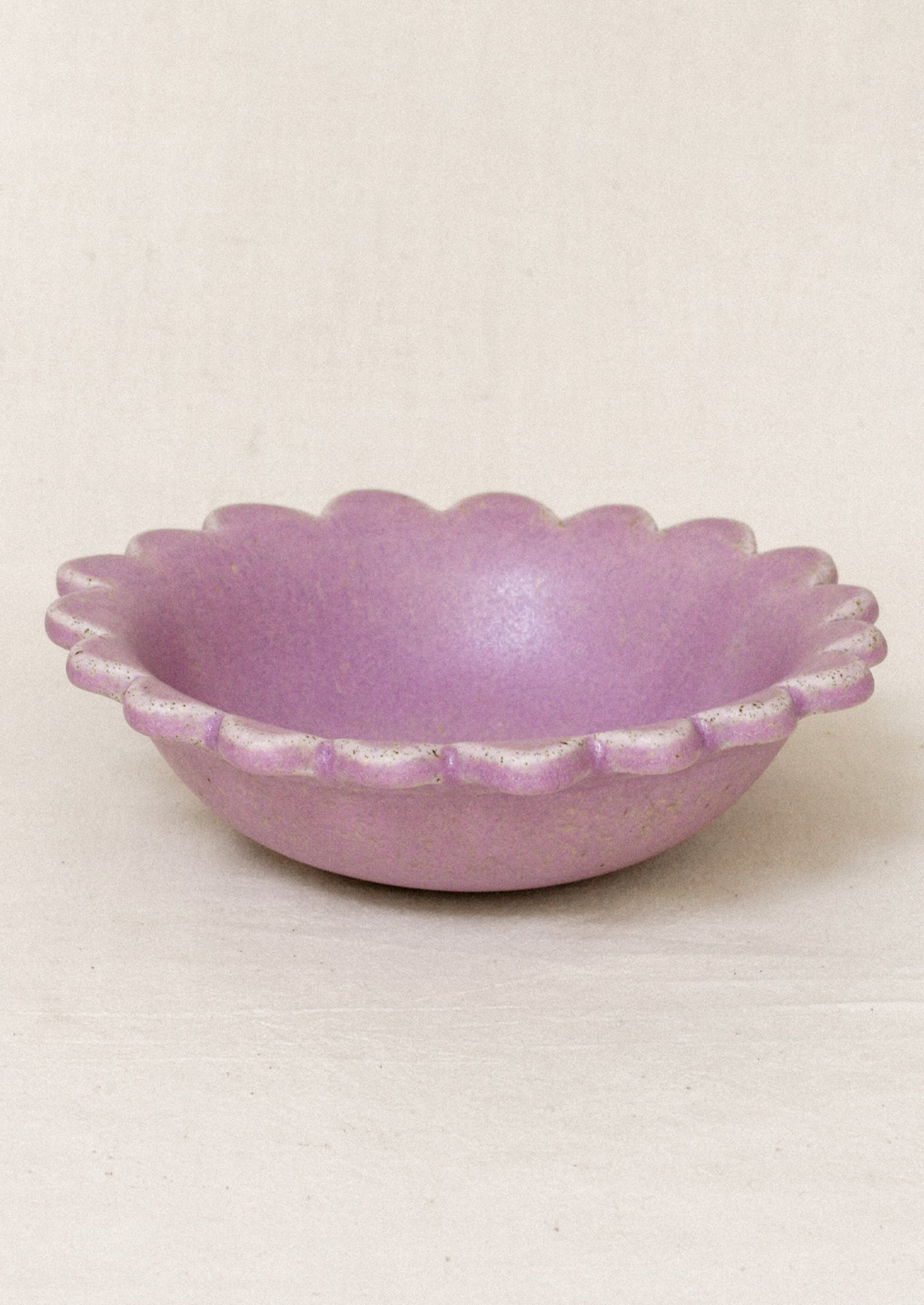 A ceramic scalloped edge bowl in a lilac color.