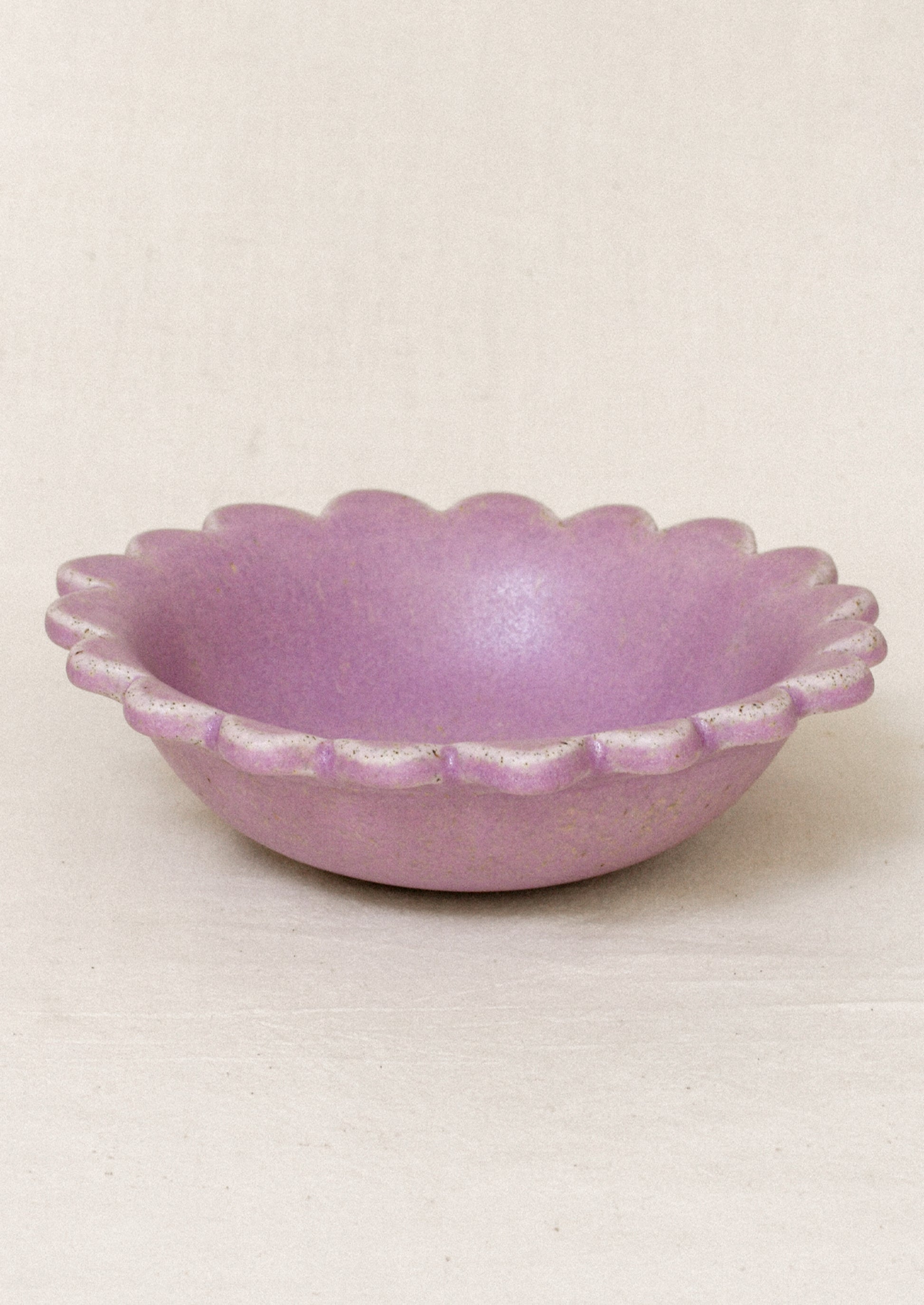 A ceramic scalloped edge bowl in a lilac color.