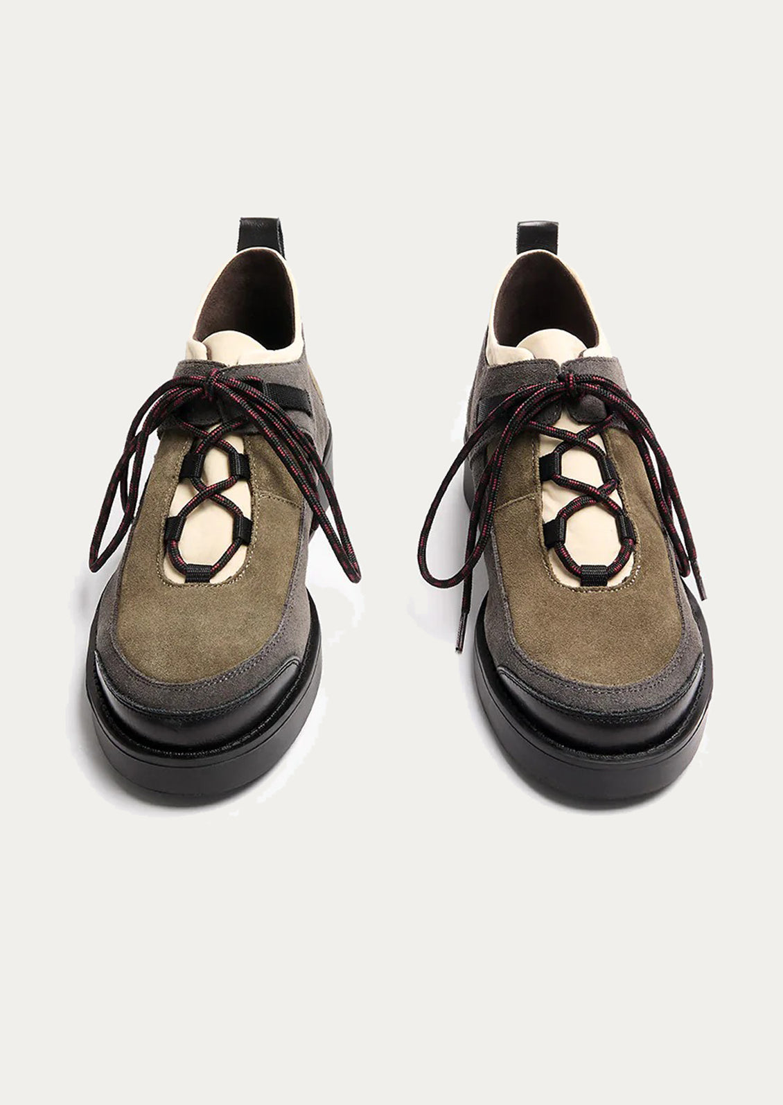 Pair of green and black shoes with unique sole design on a light gray background